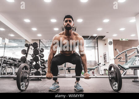 Muscular Man Doing Heavy Deadlift Exercise. Young athlete getting ready for weight lifting training Stock Photo