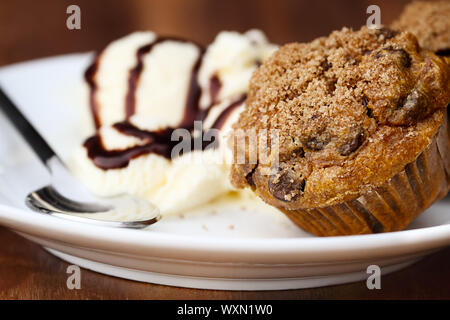 Delicious homemade pumpkin chocolate chip muffins with french vanilla ice cream. Extreme shallow depth of field. Stock Photo