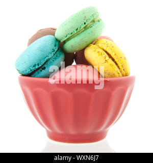 Colorful French macaroons in bowl isolated over white background Stock Photo