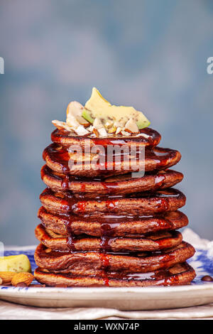 Vegan pancakes based avocado with cocoa and date syrup. Vegan healthy sweet food. Blue background Stock Photo