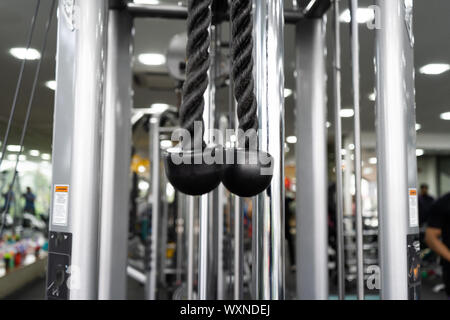 cross cable haddle hanging closeup at GYM Stock Photo