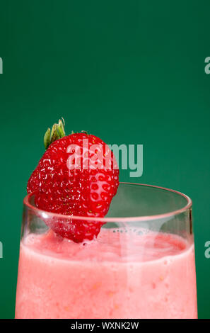 A fresh summer strawberry drink isolated on green Stock Photo