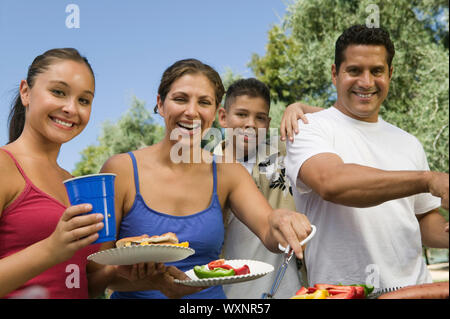 Family Gathered Around Grill Stock Photo