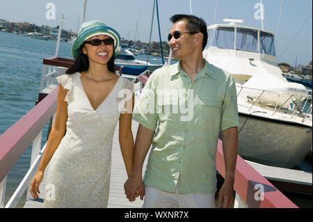Happy Couple Holding Hands on Docks Stock Photo