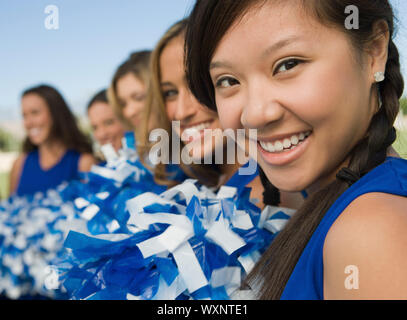Cheerleaders Sitting on Bench Stock Photo