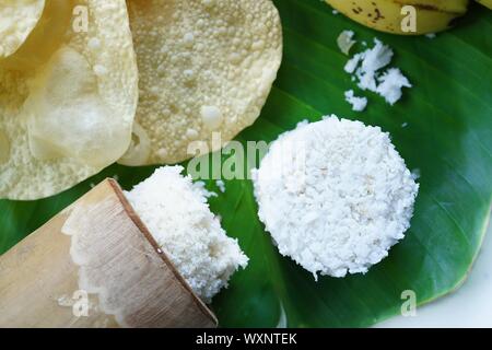 Kerala breakfast white rice puttu made in bamboo mould with Papad and banana, top view selective focus Stock Photo