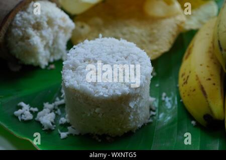 Kerala breakfast white rice puttu made in bamboo mould with Papad and banana, top view selective focus Stock Photo