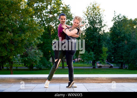 Young passionate couple dancing tango in city park Stock Photo