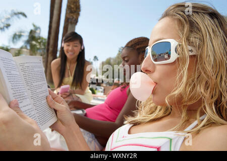 Three Young Women Relaxing Outdoors Stock Photo