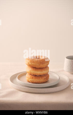 Stack of homemade baked donuts sitting on white plate Stock Photo