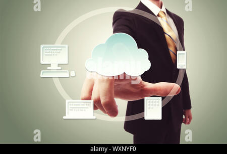 Businessman pressing cloud icon with devices over vintage green background Stock Photo