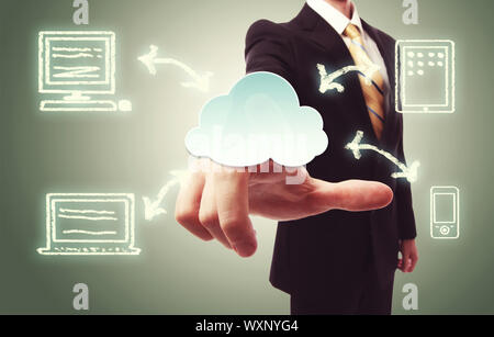 Businessman pressing a cloud icon with devices over vintage green background Stock Photo