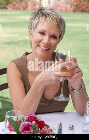 Smiling Woman Enjoying a Glass of White Wine Stock Photo