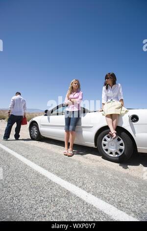Three friends experiencing car breakdown Stock Photo