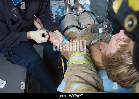 Firefighter and paramedic helping woman in ambulance Stock Photo