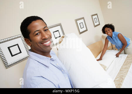 Couple Making Bed Stock Photo