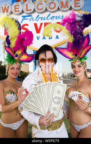 Female dancers and Elvis impersonator posing in front of Las Vegas welcome sign, Nevada, USA Stock Photo