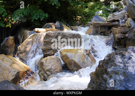 Fast flowing water through rocks in the Alps Stock Photo