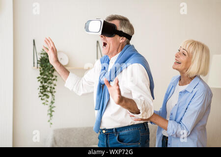 Mature man using vr goggles, having fun at home Stock Photo