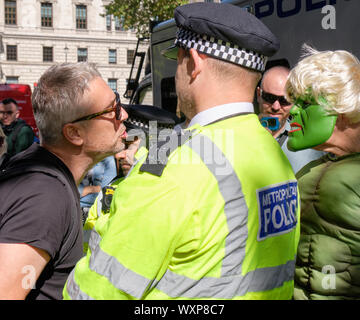 London, UK. 17th September 2019.  Demonstrator holding protest outside the Supreme Court, waiting for the ruling on the Legal challenge to the Prorogation of parliament. Pro Leave protester challenging Pro defend democracy supporter in Hulk costume and Johnson wig under watchful eye of policeman  in wake of Brexit deadline . Credit: JF Pelletier/Alamy Live News.