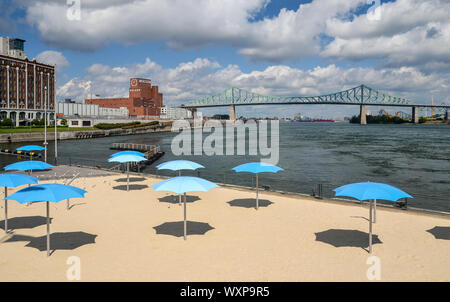 MONTREAL,CANADA - SEPTEMBER 16, 2014: Clock Tower Beach with blue parasols located at the entrance of the old port of Montreal. Stock Photo