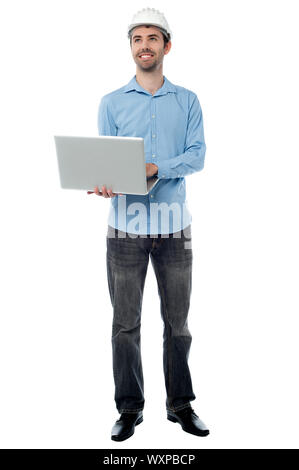 Male architect browsing on his laptop, looking up Stock Photo