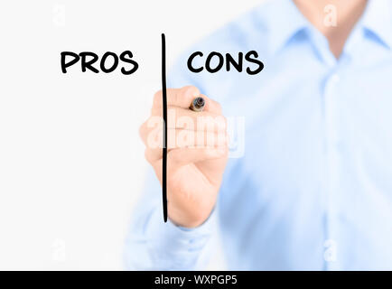 Young businessman holding  a marker and writing pros and cons comparison concept for weigh all arguments. Isolated on white background. Stock Photo