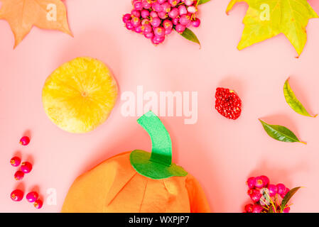 Autumnal background with leaves and berries next to a pumpkin cloth. Stock Photo