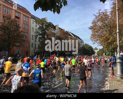 Berlin, Germany - September 16, 2018: People running at Berlin Marathon over tons of Empty Plastic Cups Stock Photo