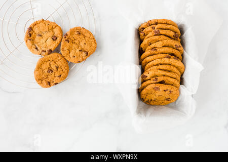 Top view of homemade chocolate chip cookies in a baking form and cooling rack. Stock Photo