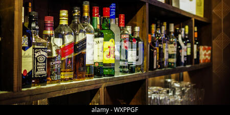 Shanghai, China - Dec 16, 2015: Jack Daniel's, Johnnie Walker, Macallan, Chivas and Jameson whisky bottles on bar counter shelf with dust Stock Photo