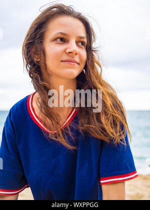 Caucasian brunette girl without makeup with wet hair in a blue t-shirt, in nature portreit Stock Photo