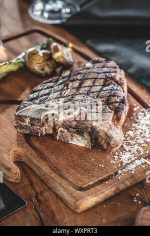 Barbecue beef t-bone  steak  served on wooden serving plate with grilled vegetables Stock Photo