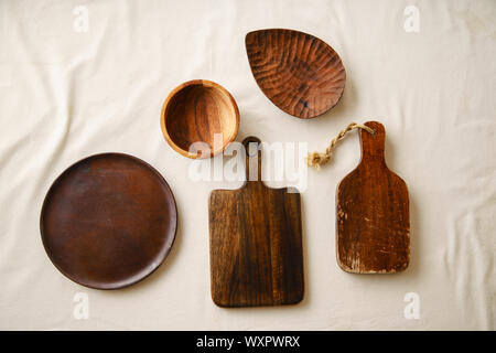 Various wooden tableware. Cutting boards, plate and bowl on linen tablecloth Stock Photo