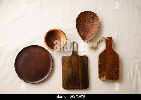 Various wooden tableware. Cutting boards, plate and bowl on linen tablecloth Stock Photo
