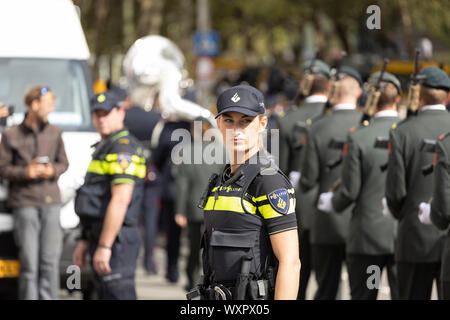 Female police officer securing the road where a military parade passes by on Prinsjesdag in Den Haag Stock Photo