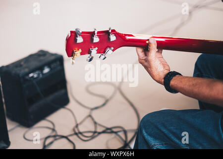 Back view of man's hand playing an electric guitar. Selective focus. Copy space. Stock Photo