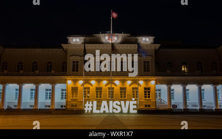 A picture of the Presidential Palace of Vilnius, at night, with a large illuminated sign that says 'Freedom'. Stock Photo