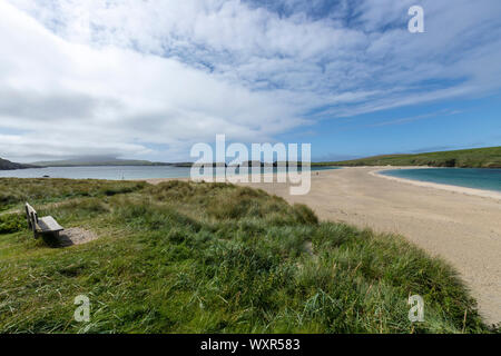 Wooden bench looking the St Ninian’s beach with St Ninian's Isle, connected by a tombolo, Mainland, Shetland, Scotland, UK Stock Photo