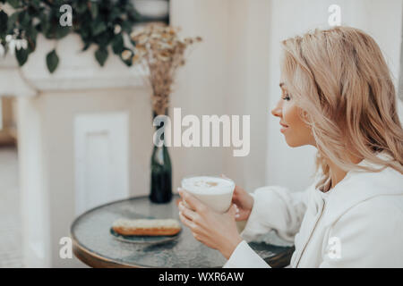 business woman sitting in a cafe with cup of coffee and talking on the phone Stock Photo