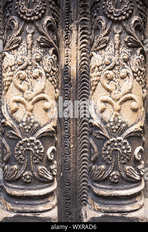 Ancient columns with Renaissance bas-reliefs and plants patterns in the wall Stock Photo