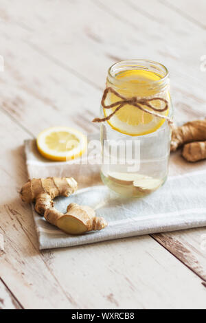 Ginger with lemon detox water in the morning on wooden background. Stock Photo
