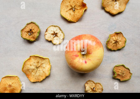 Fresh apple with pieces of dry apples on the table, top view Stock Photo