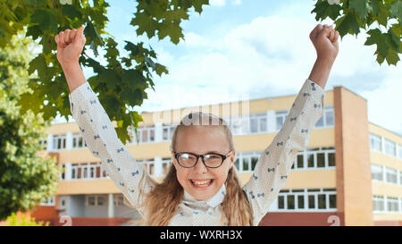 Happy eleven year old schoolgirl jumps in happy emotions. Stock Photo