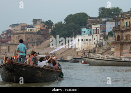 International tourists taking boat ride on Ganges river at Varanasi to experience the beauty of this city. Stock Photo