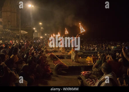 Enthusiastic priests performing evening prayer at the river bank in Varanasi Stock Photo