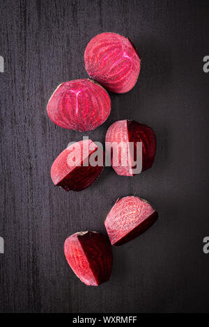 Tasty raw beetroot. Sliced beetroot on black kitchen table. Top view. Stock Photo