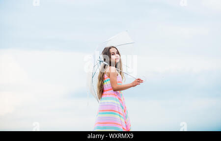Happy childhood. I believe i can fly. Touch sky. Fairy tale character. Feeling light. Girl with light umbrella. Anti gravitation. Fly drop parachute. Dreaming about first flight. Kid pretending fly. Stock Photo