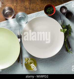 empty plates on a table set for guests. plates and cutlery. dinner or lunch styling Stock Photo