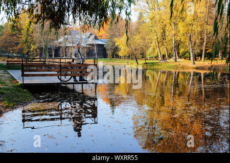 The man with the bike standing on the pier and watching the lake. Stock Photo